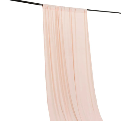 Sheer blush pink curtain draped on a black rod