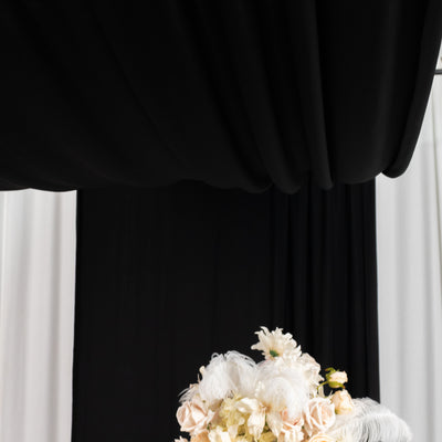 Elegant floral arrangement with feathers on a decorative table.