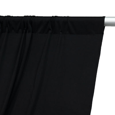 Black curtain fabric draped on a curtain rod, showcasing smooth texture.