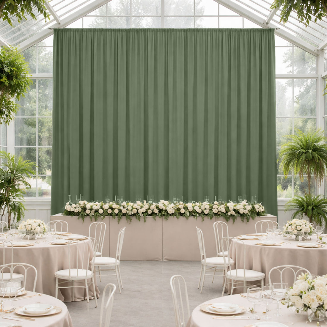 Elegant green backdrop in a decorated event space with floral arrangements.