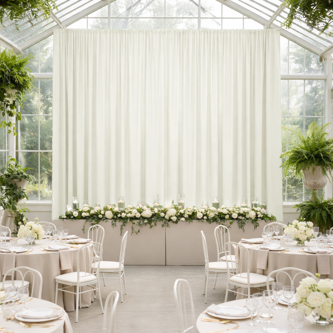 Elegant wedding reception with floral decor in a bright, airy greenhouse setting.