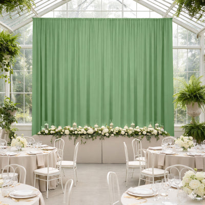 Elegant green backdrop with floral arrangement in a styled event setting.