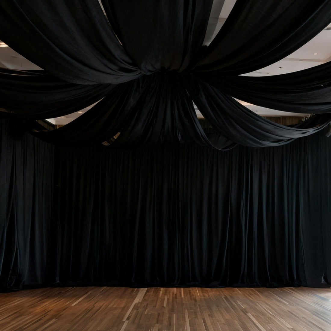 Black drapery ceiling installation in a spacious event venue.