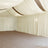 Elegant cream drapery and soft lighting in a spacious interior setting.