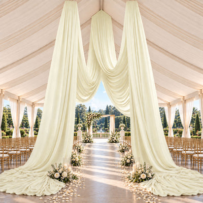 Elegant luxury wedding tent with ivory drapery, floral aisle, and garden backdrop