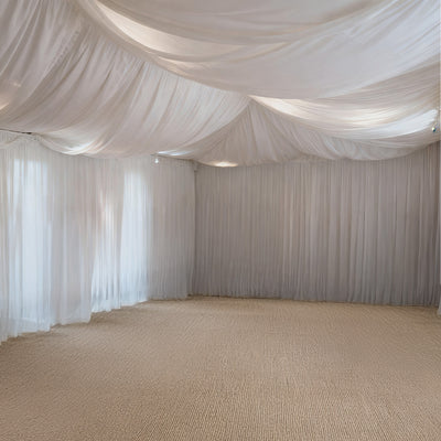Elegant white drapery and soft carpet in a spacious event venue.