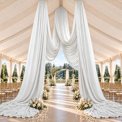 Elegant outdoor wedding ceremony tent with white drapery and floral aisle