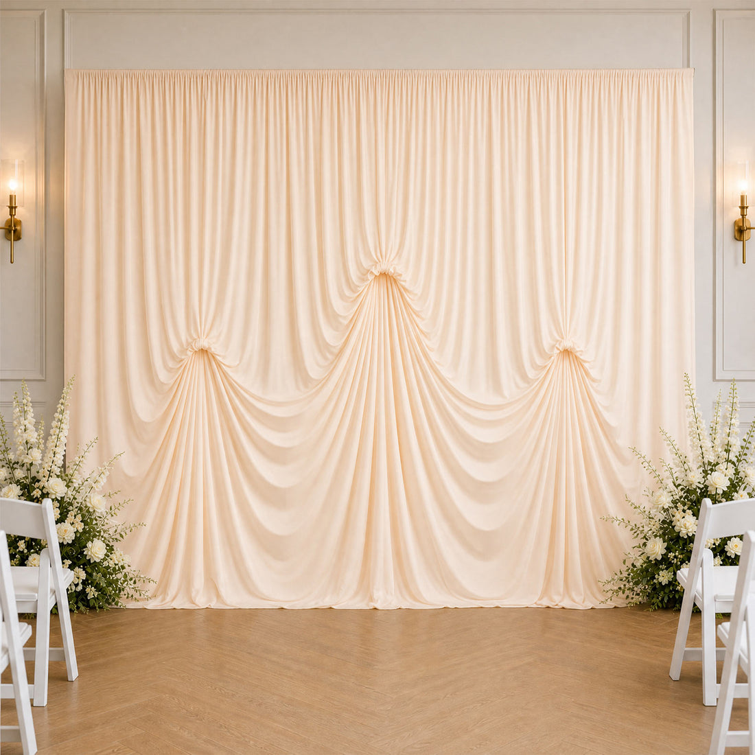 Elegant cream wedding backdrop with draped curtains and floral arrangements