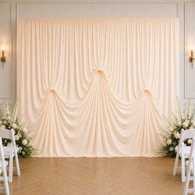 Elegant cream wedding backdrop with draped curtains and floral arrangements