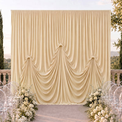 Elegant outdoor wedding backdrop with cream draped curtains and white floral décor