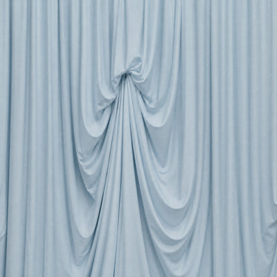 Soft blue draped fabric backdrop with elegant gathered folds
