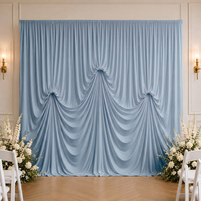 Elegant blue wedding drapery backdrop with white floral arrangements