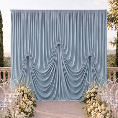 Elegant blue draped wedding backdrop with white floral aisle decor outdoors