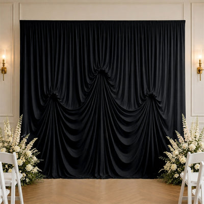 Elegant black draped wedding backdrop with white floral arrangements and chairs
