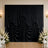 Elegant black draped wedding backdrop with white floral arrangements and chairs