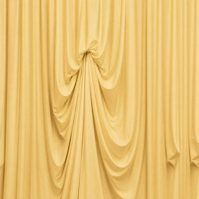 Draped gold fabric curtain with elegant folds and soft texture