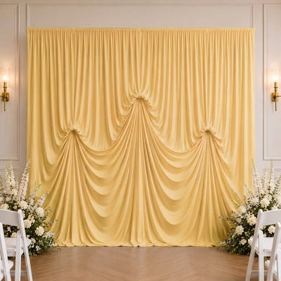 Elegant gold wedding drapery backdrop with white floral arrangements