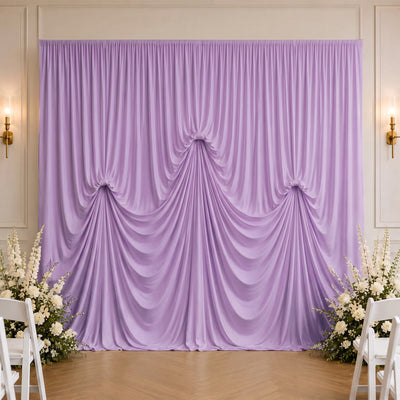 Lavender draped wedding backdrop with floral arrangements and white chairs