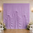 Lavender draped wedding backdrop with floral arrangements and white chairs