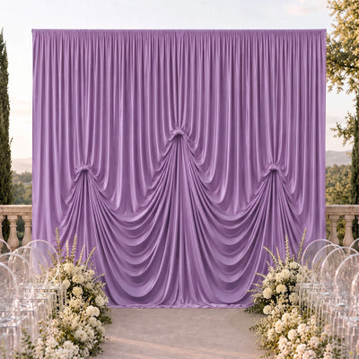 Lavender wedding backdrop with draped satin curtains and floral aisle decor