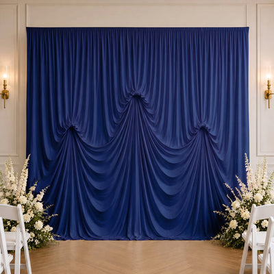 Elegant blue draped wedding backdrop with white floral arrangements