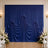 Elegant blue draped wedding backdrop with white floral arrangements