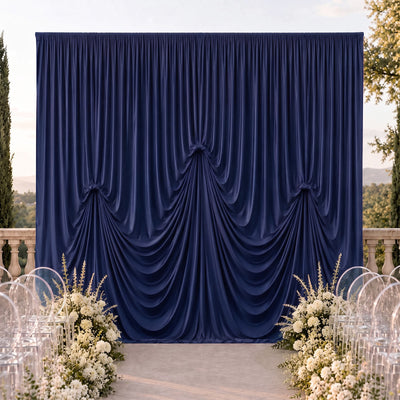Elegant navy blue draped wedding backdrop with white floral aisle decor
