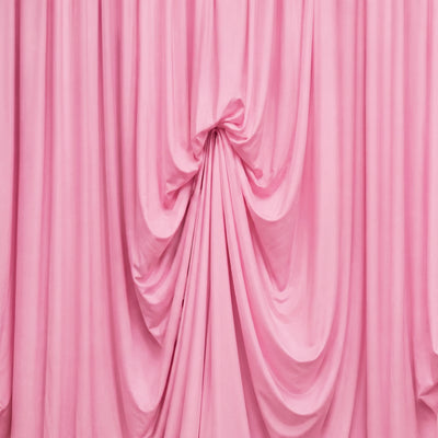 Pink draped fabric backdrop with elegant folds and soft texture