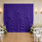 Elegant purple wedding backdrop with white floral arrangements and chairs