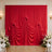 Red draped wedding backdrop with white floral arrangements in elegant venue