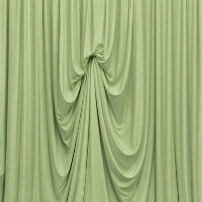Abstract pale green draped curtain with soft fabric folds and gathered center
