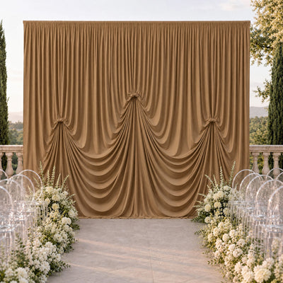Elegant outdoor wedding ceremony backdrop with gold drapery and white flowers