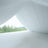 White draped fabric with greenery view through an open space.