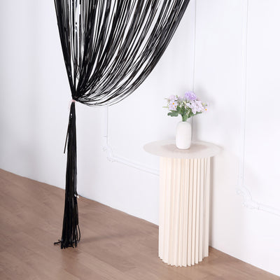 Modern white vase with flowers on a stylish round pedestal table.