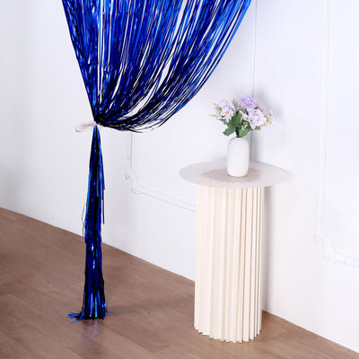 Decorative blue fringe curtain with a flower vase on a modern round table.