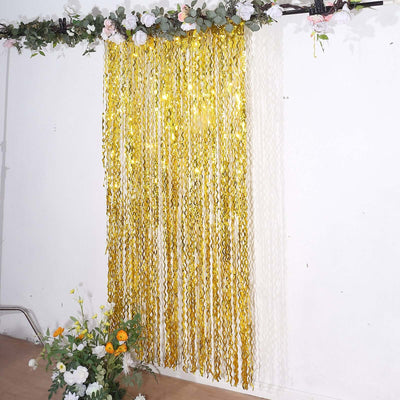 Gold fringe curtain backdrop with floral accents for events and celebrations.