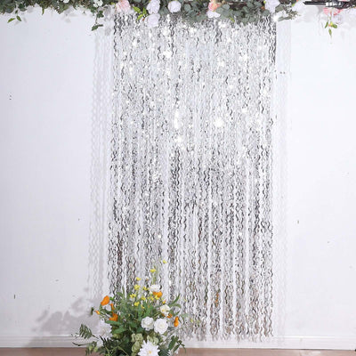 Silver fringe curtain decoration with floral accents.