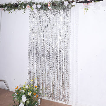 Create a Captivating Setting with the Metallic Silver Wavy Tinsel Streamer Party Backdrop