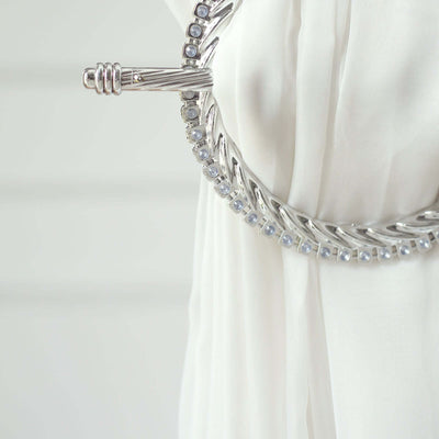 Silver decorative brooch with blue stones on white fabric