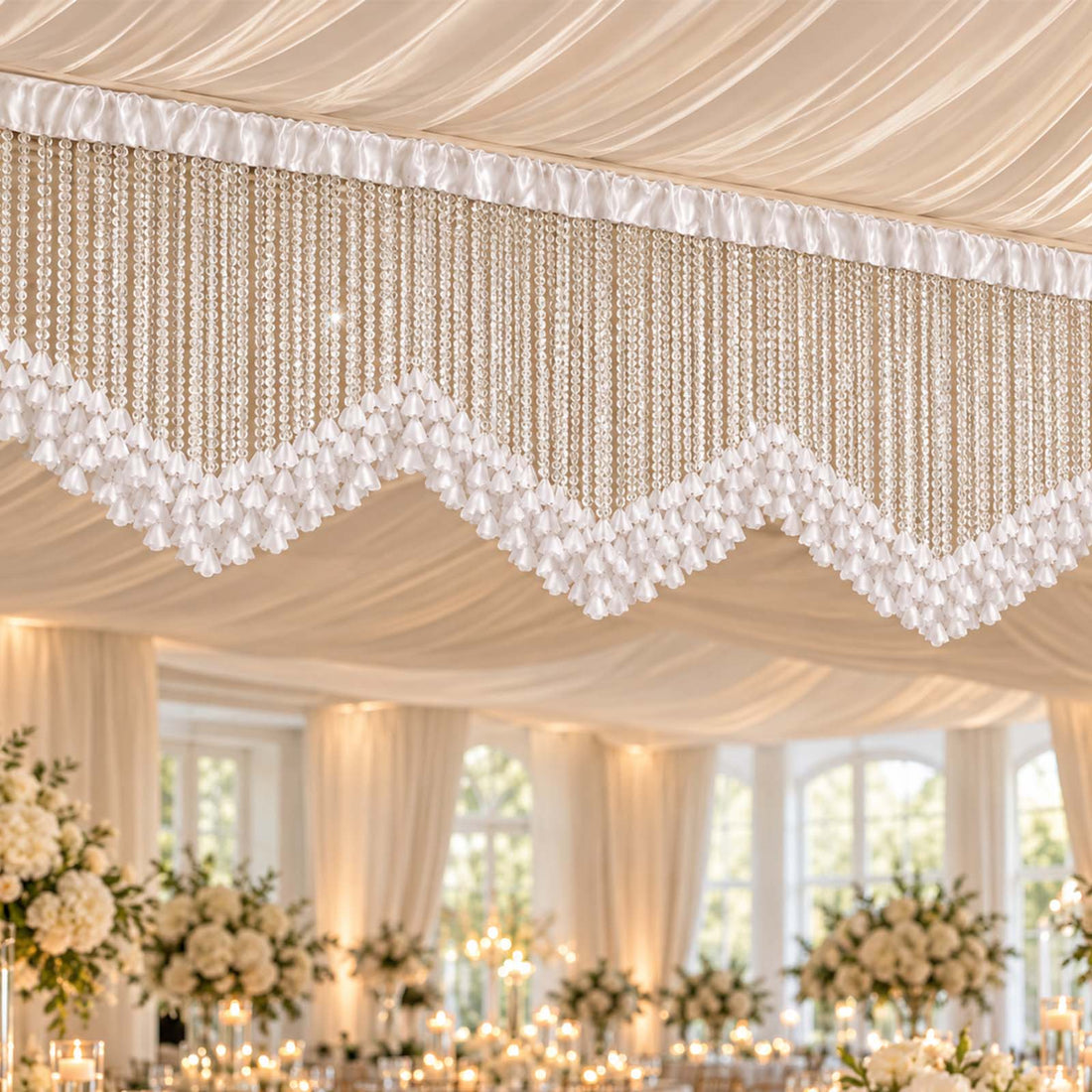 Elegant wedding reception ceiling decor with white draped fabric and crystal chandeliers
