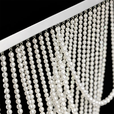 Close-up of cascading pearl strands on a silver frame.