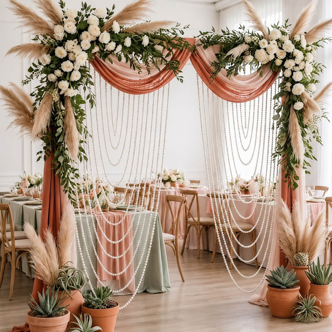 Boho wedding ceremony arch with roses, pampas grass, and pearl drapes