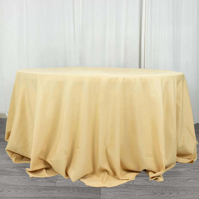 Round beige tablecloth draped on a circular table.