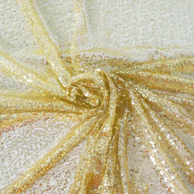 Gold sequin fabric draped in elegant folds for crafting and fashion projects.