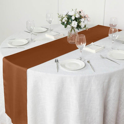 Brown satin table runner on a round table set for dining.