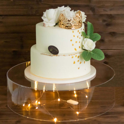 Elegant two-tier cake adorned with roses and a gold crown.