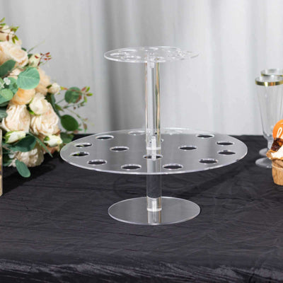 Acrylic display stand for cupcakes or desserts on a dark table.