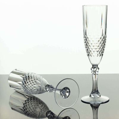 Crystal champagne flutes on a reflective surface