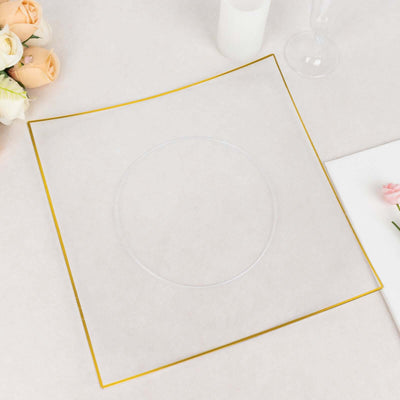Clear plate with gold rim on a light surface, surrounded by flowers.