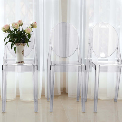 Transparent acrylic chairs with a vase of roses in a bright room.